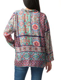 Multicolored patterned blouse worn by a person on a white background